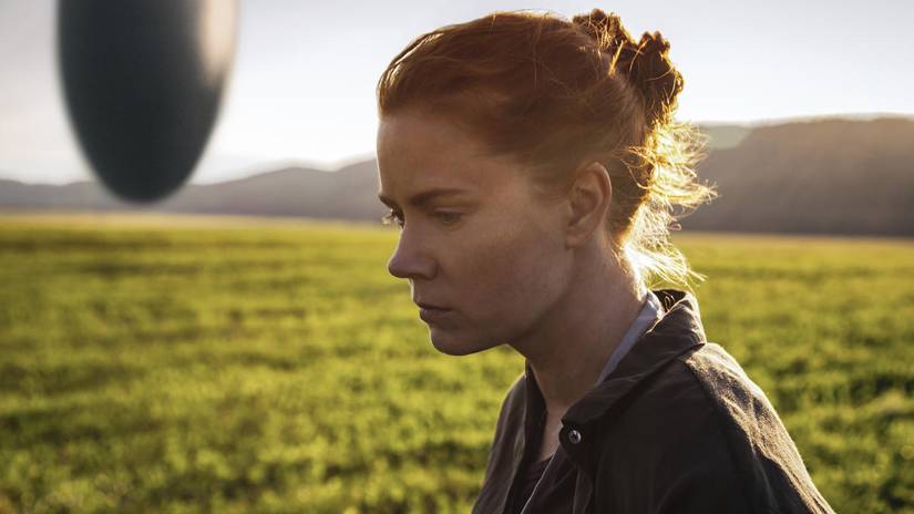 Amy Adams di depan cangkang kerang dalam film Arrival.