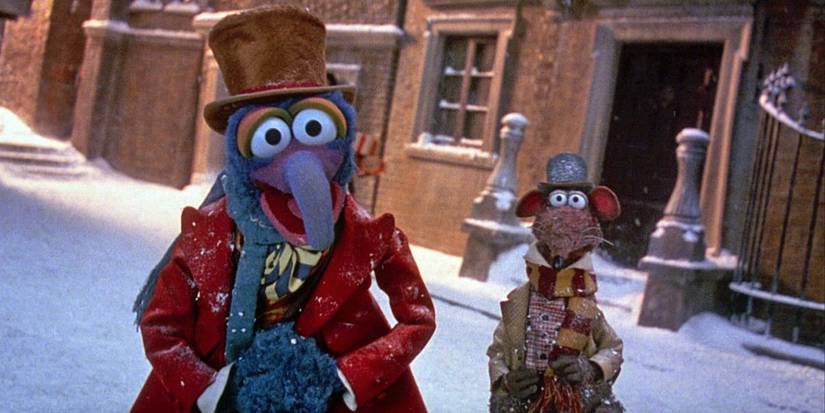 The Muppet Gonzo walking down a street covered in snow dressed in old timely clothes with a top hat in The Muppet Christmas Carol