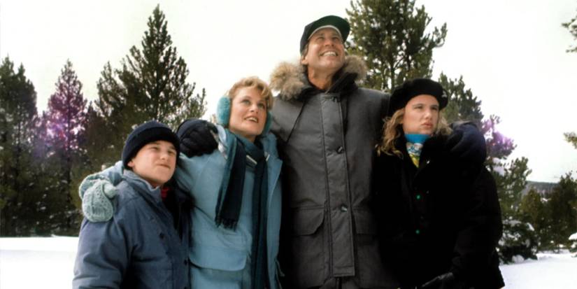 National Lampoon's Christmas Vacation cast, including Chevy Chase as Clark Griswold, Beverly D'Angelo as Ellen Griswold, Juliette Lewis as Audrey Griswold, and Johnny Galecki as Rusty Griswold, wearing heavy coats in the snow