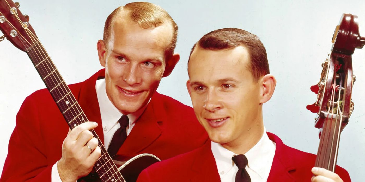 Dick and Tom Smothers with a guitar and harp in their hands and red jackets on in The Smothers Brothers Comedy Hour