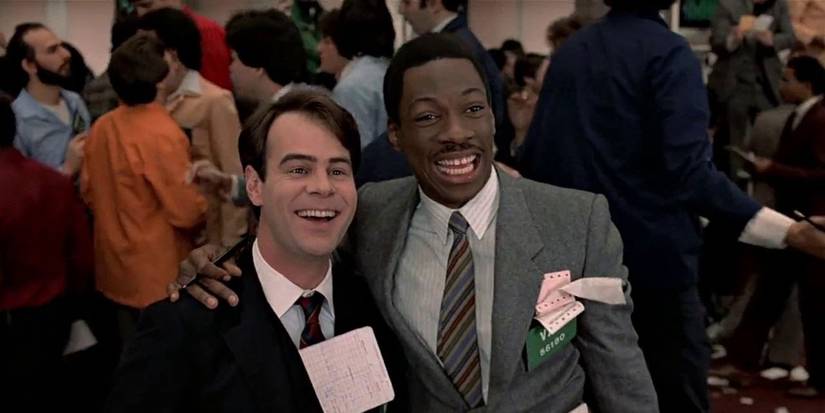 Billy Ray with his arm around Louis at a gala, both in suits in a scene from Trading Places.