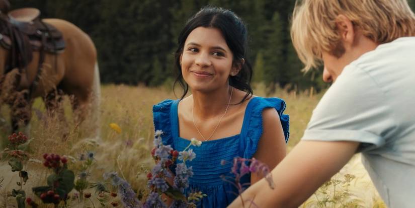 Nikki Rodriguez as Jackie and Noah LaLonde as Cole sitting in a field in My Life With the Walter Boys