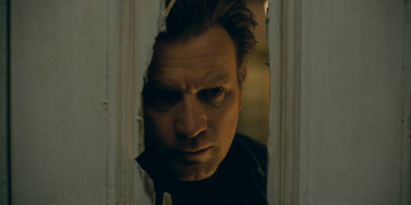 Ewan McGregor looks through a cracked door in the film Doctor Sleep