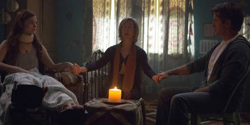 A group of people hold a seance in the film insidious chapter 3