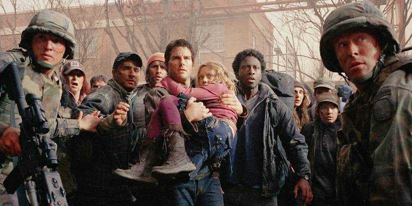 Tom Cruise holds a young Dakota Fanning, as they're surrounded by military personnel