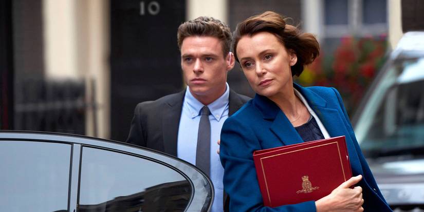 David standing at the car with the politician he's protecting in a scene from Bodyguard.