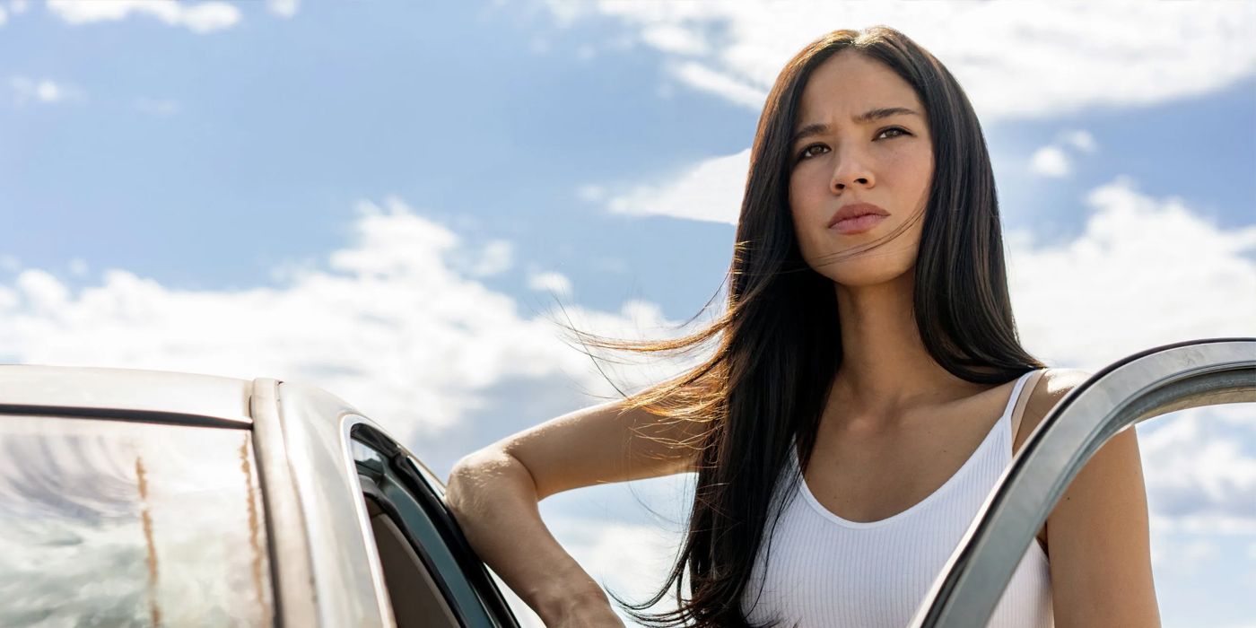 Kelsey Asbille as Monica Long Dutton leaning against a truck with the door open in Yellowstone