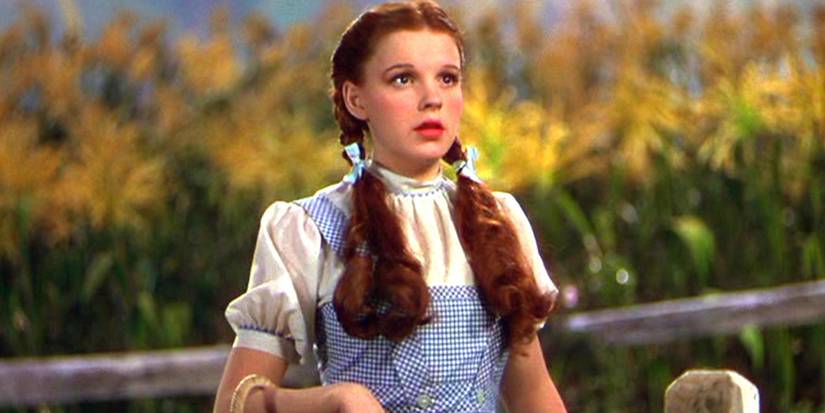 Judy Garland as Dorothy Gale standing near a corn field in The Wizard of Oz (1939)