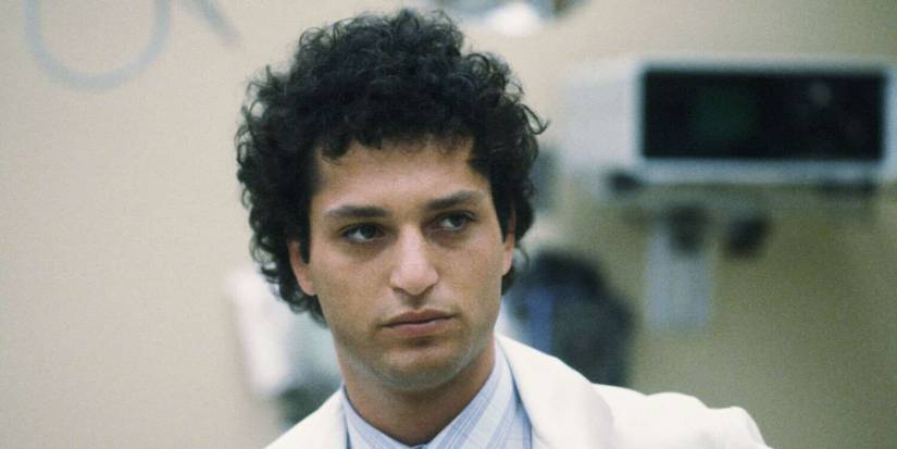 Howie Mandel as Dr. Wayne Fiscus looking off-screen in a medical office in St. Elsewhere