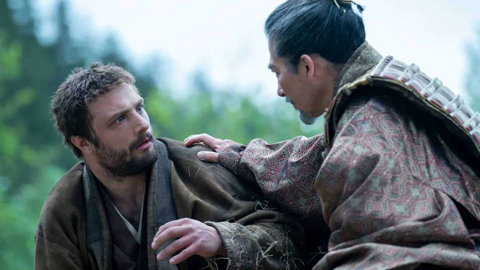 Hiroyuki Sanada as Lord Yoshii Toranaga with Cosmo Jarvis as Blackthorne wearing a robe talking to each other in Shogun