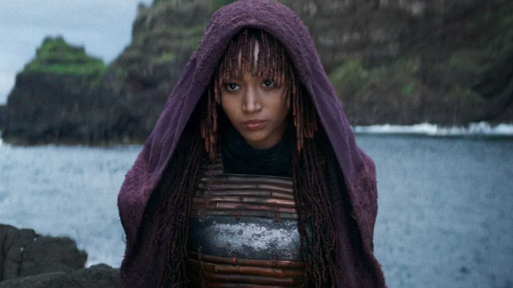 Amanda Stenberg wearing a hood standing next to the ocean in The Acolyte