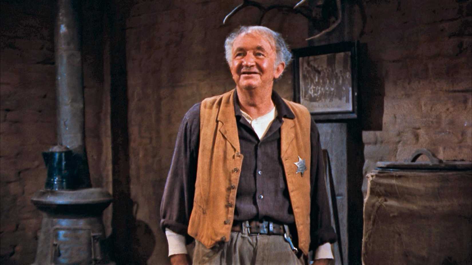 Walter Brennan wearing a brown vest in a room in Rio Bravo