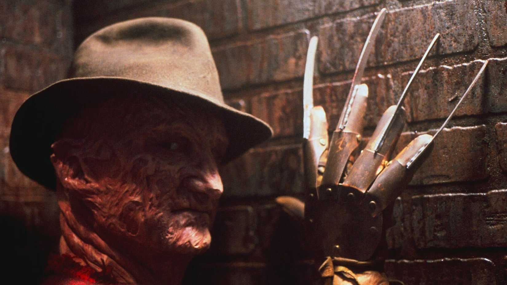 Freddy Krueger with claws against a brick wall in A Nightmare on Elm Street
