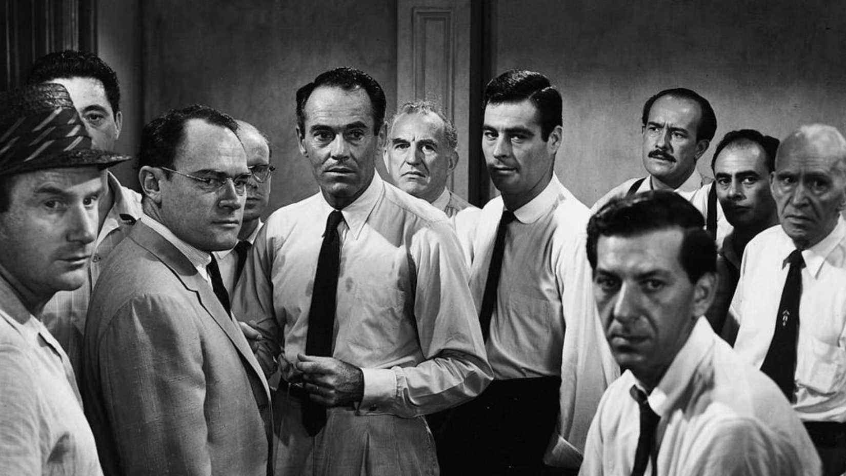 The jurors standing and staring wearing ties and suits in 12 Angry Men