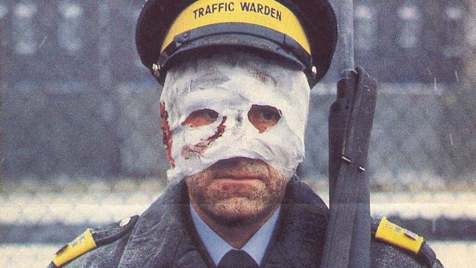 A man in a white mask with blood on it carrying a rifle in Threads