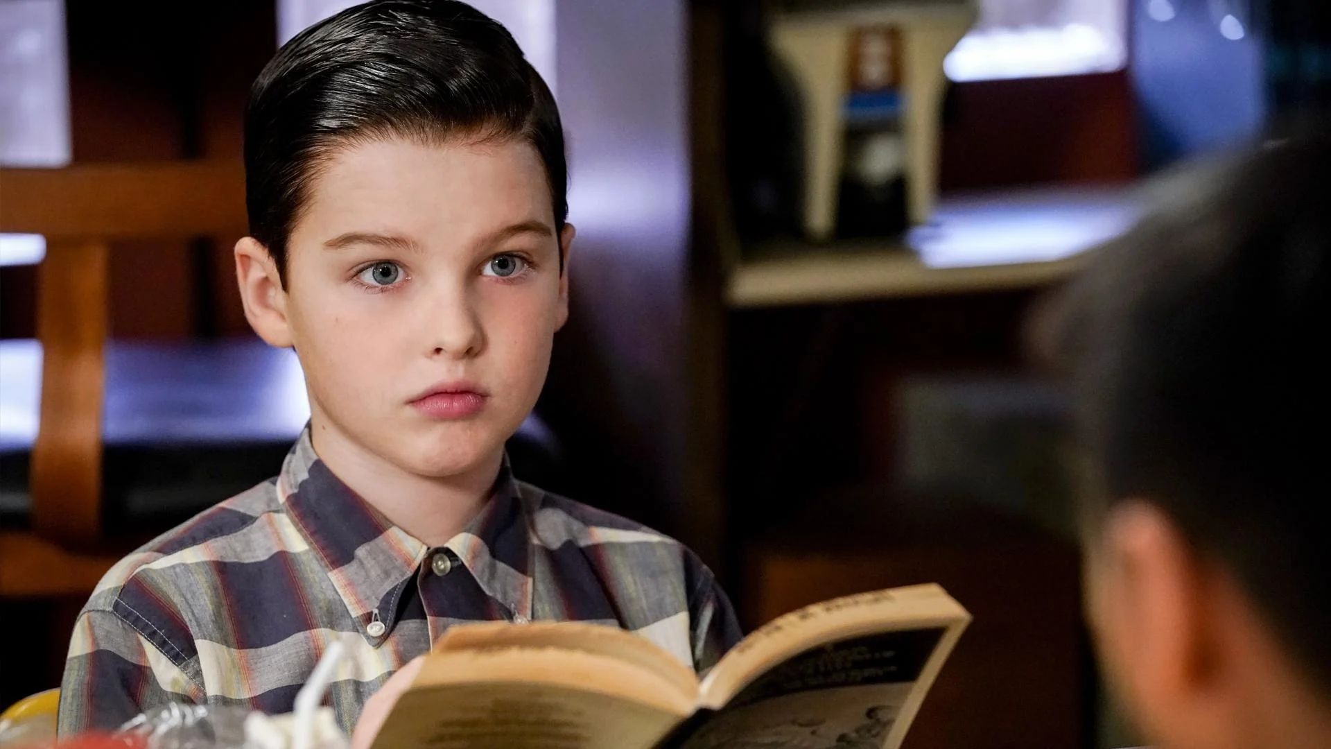 Young Sheldon's Sheldon Cooper is seen reading a book.