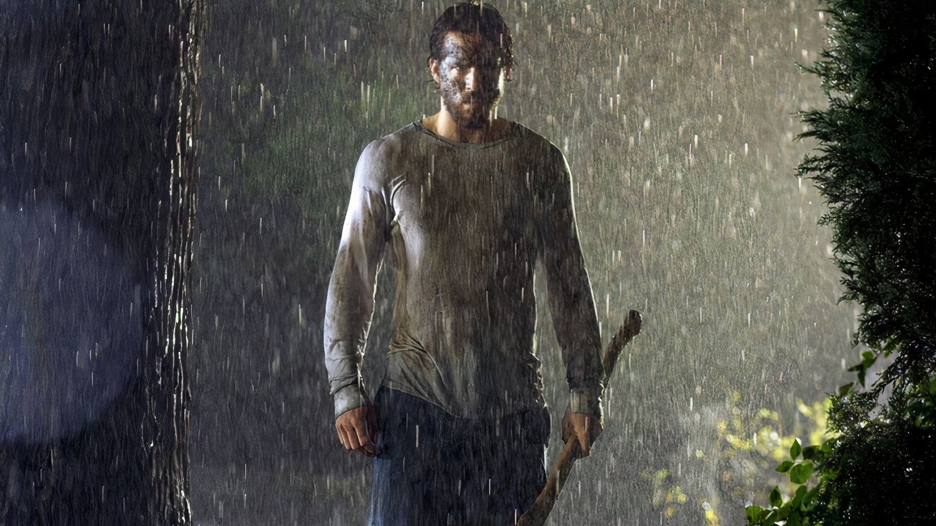Ryan Reynolds in the rain holding an axe in The Amityville Horror