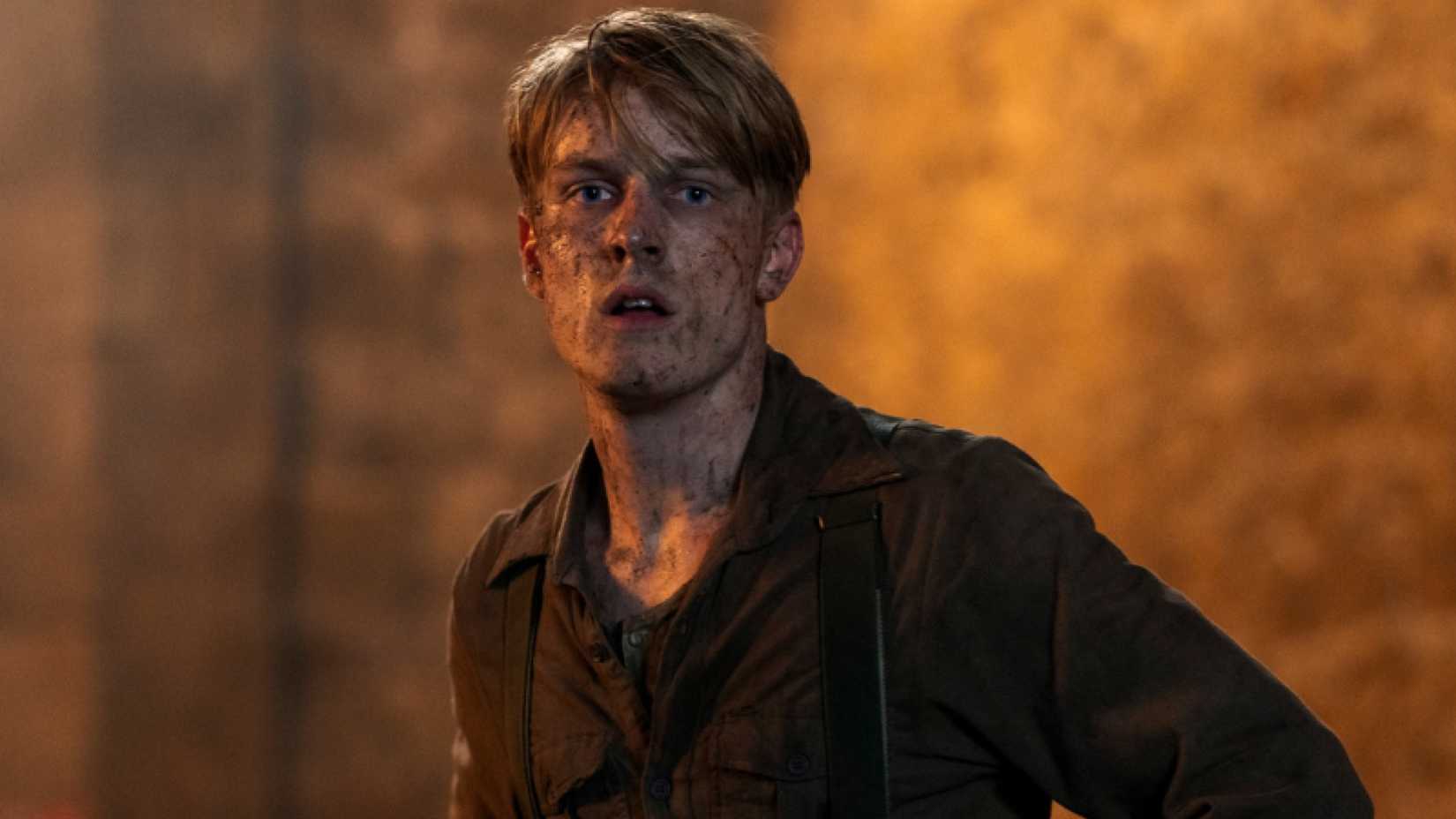 Louis Hofmann with dirt all over his face as Werner in All the Light We Cannot See