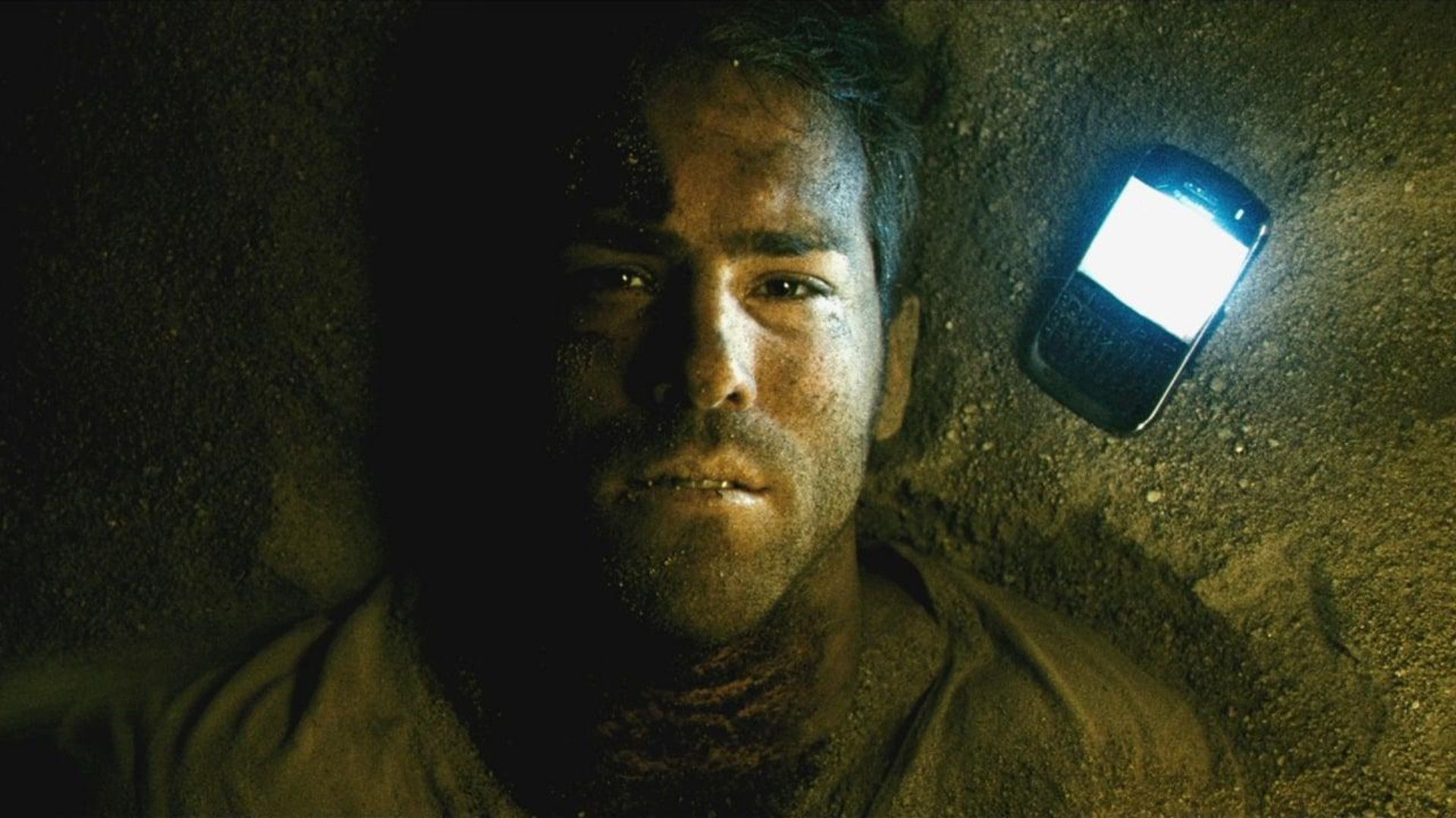 Ryan Reynolds lays next to BlackBerry phone in Buried