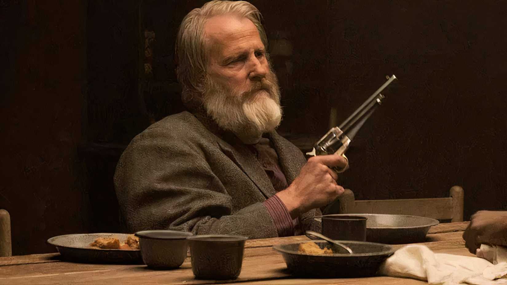 Frank holds a gun at dinner in Godless
