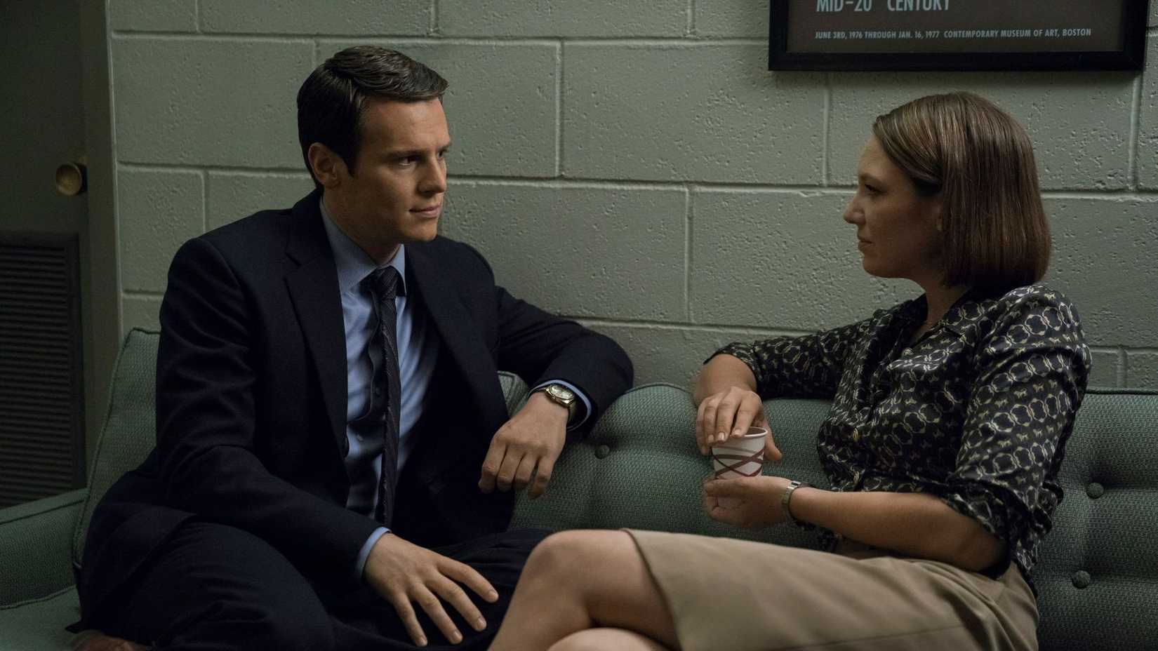 A man and woman on a couch talking in Mindhunter.