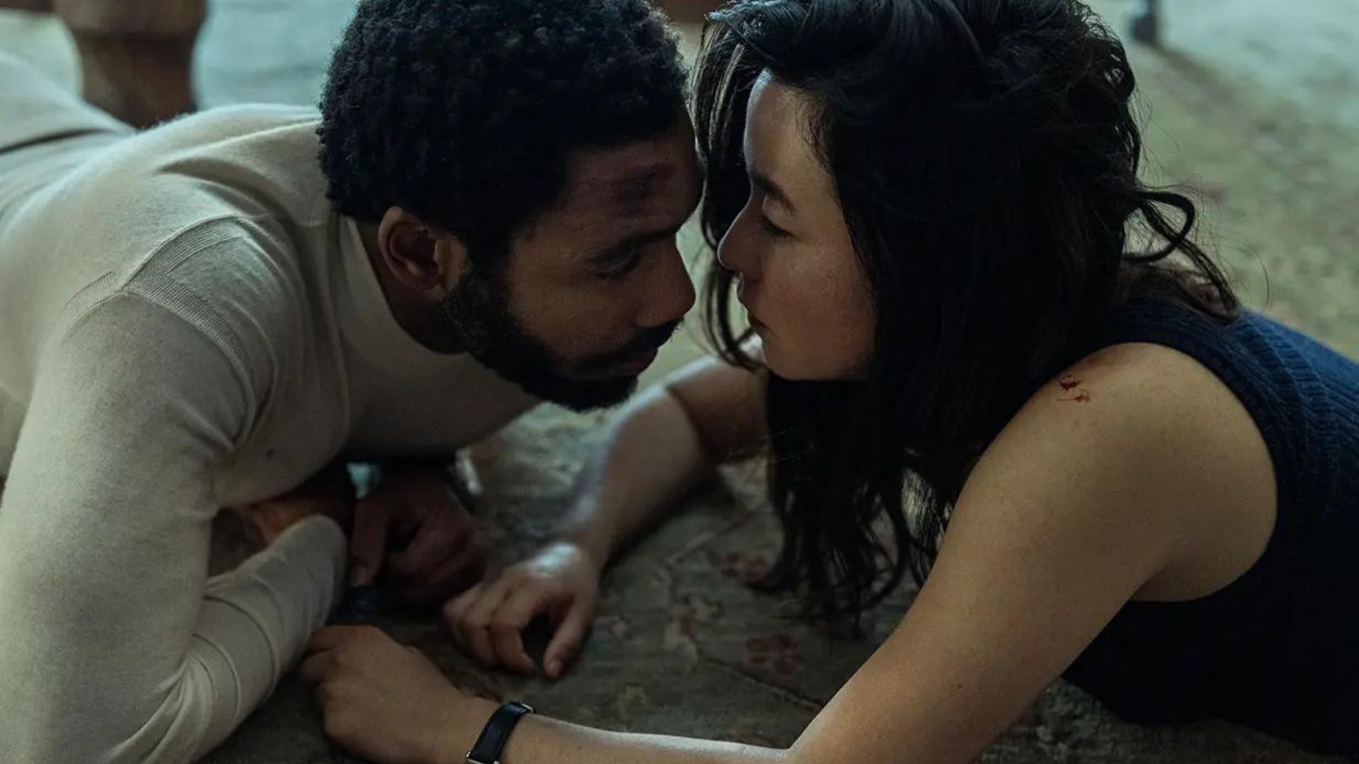 Donald Glover and Maya Erskine in Mr. & Mrs. Smith lying on the floor looking at each other