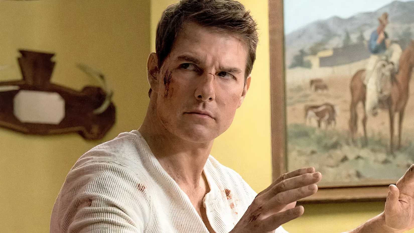 Tom Cruise as Jack Reacher wearing a white shirt with blood on it and on his cheek in Jack Reacher Never Go Back
