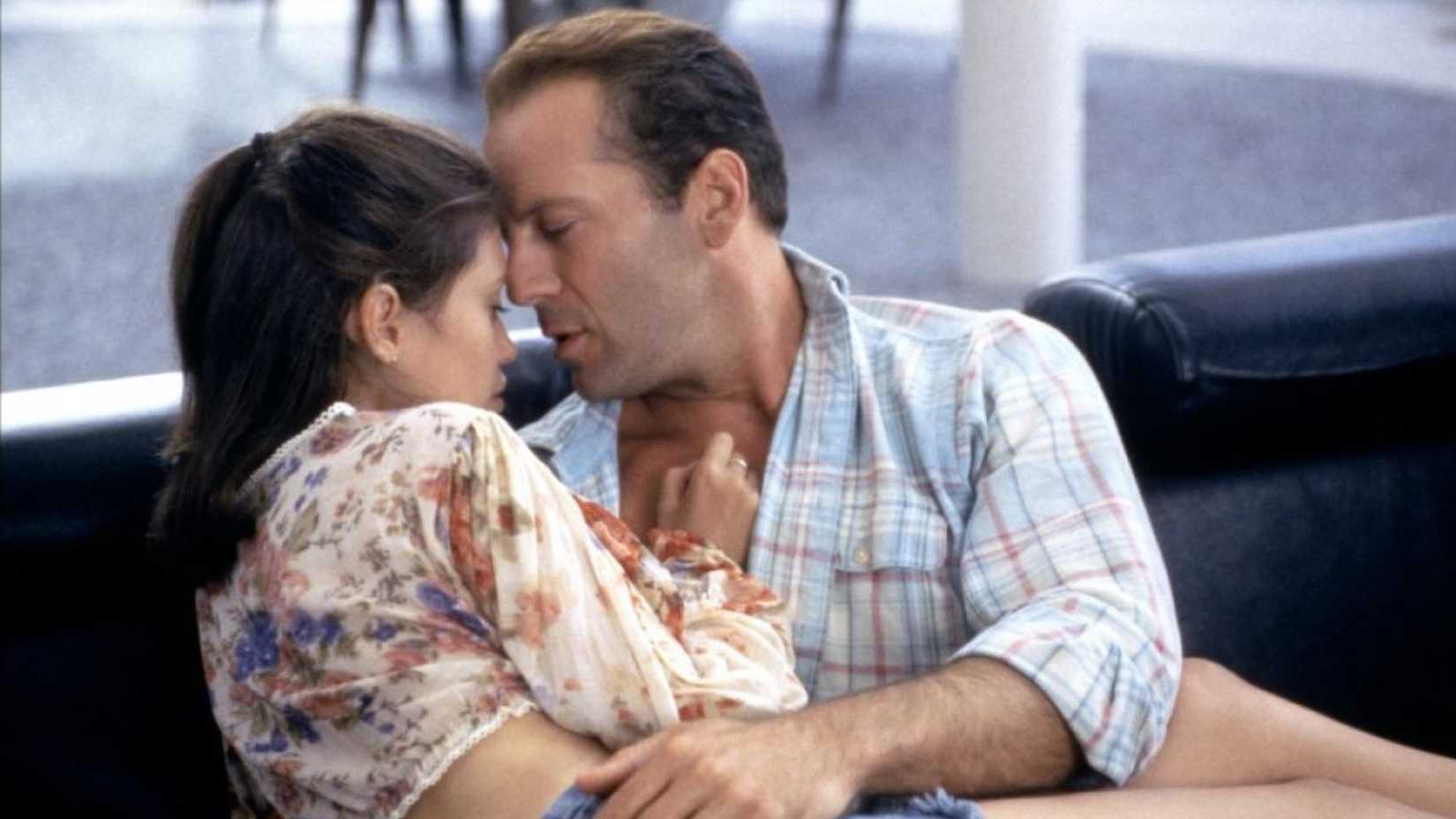 Bruce Willis and Jane March cuddling on a sofa in Color of Night