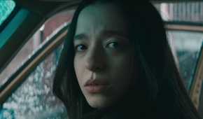 Mikey Madison in Anora in a car looking to the side directly toward the camera