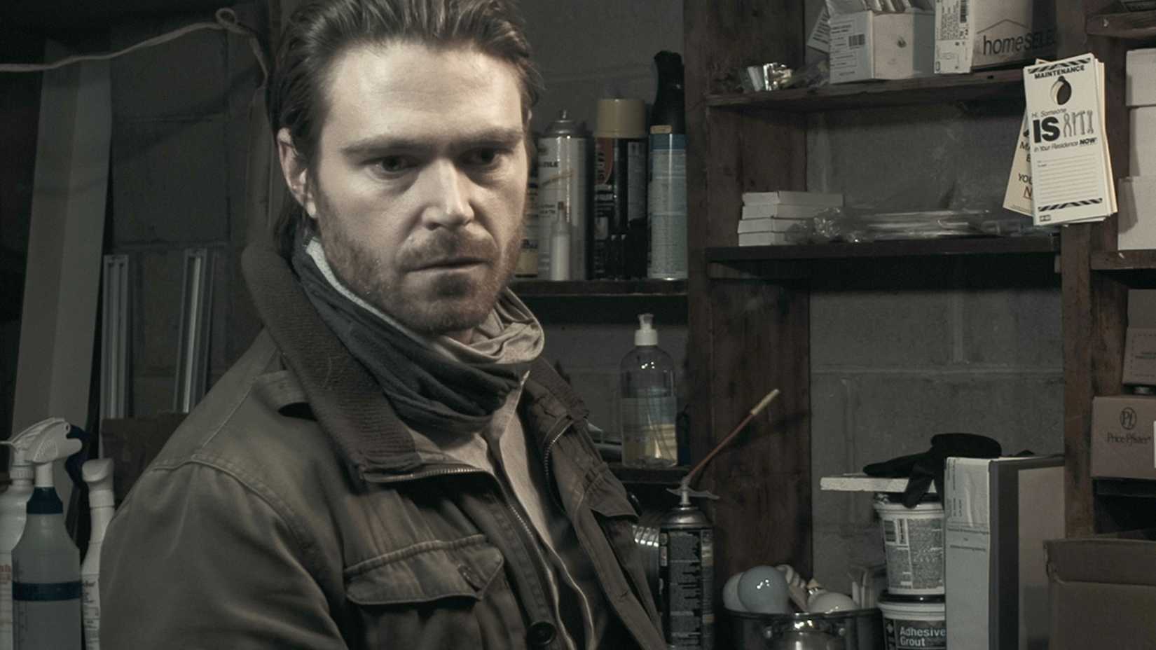 man in garage in Extramundane (2022)