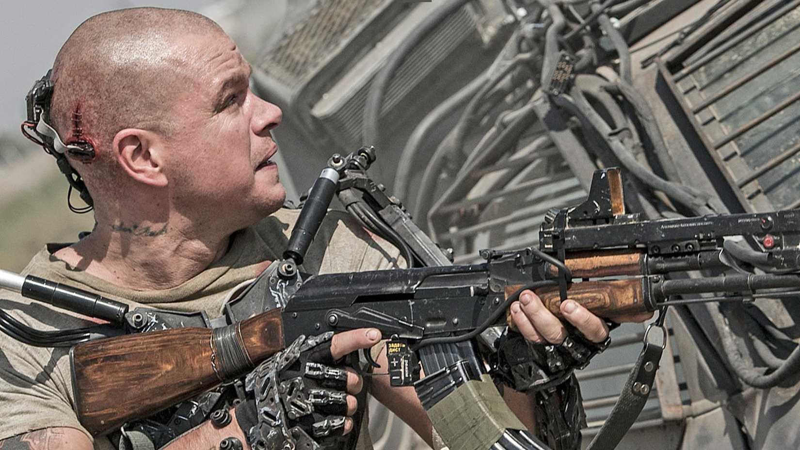 Matt Damon with a gun in Elysium.