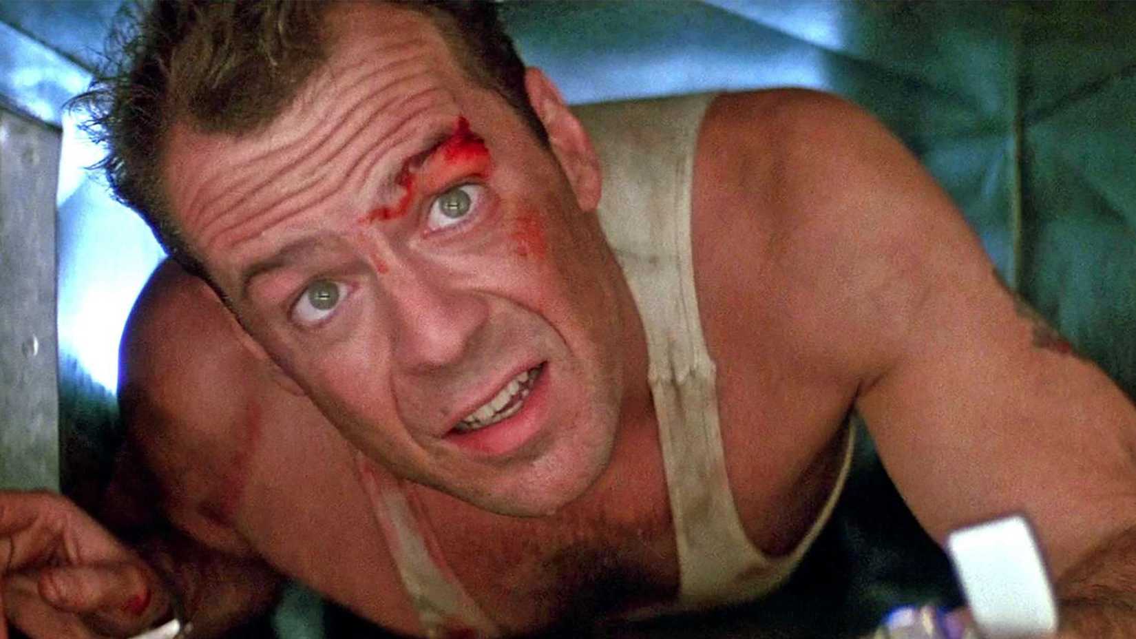 John in the vent looking up, a cut over his eye and holding a lighter in Die Hard.