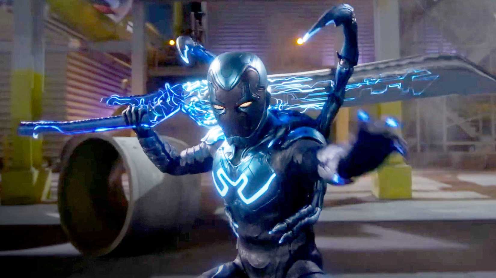 Blue Beetle in costume standing and glowing in battle