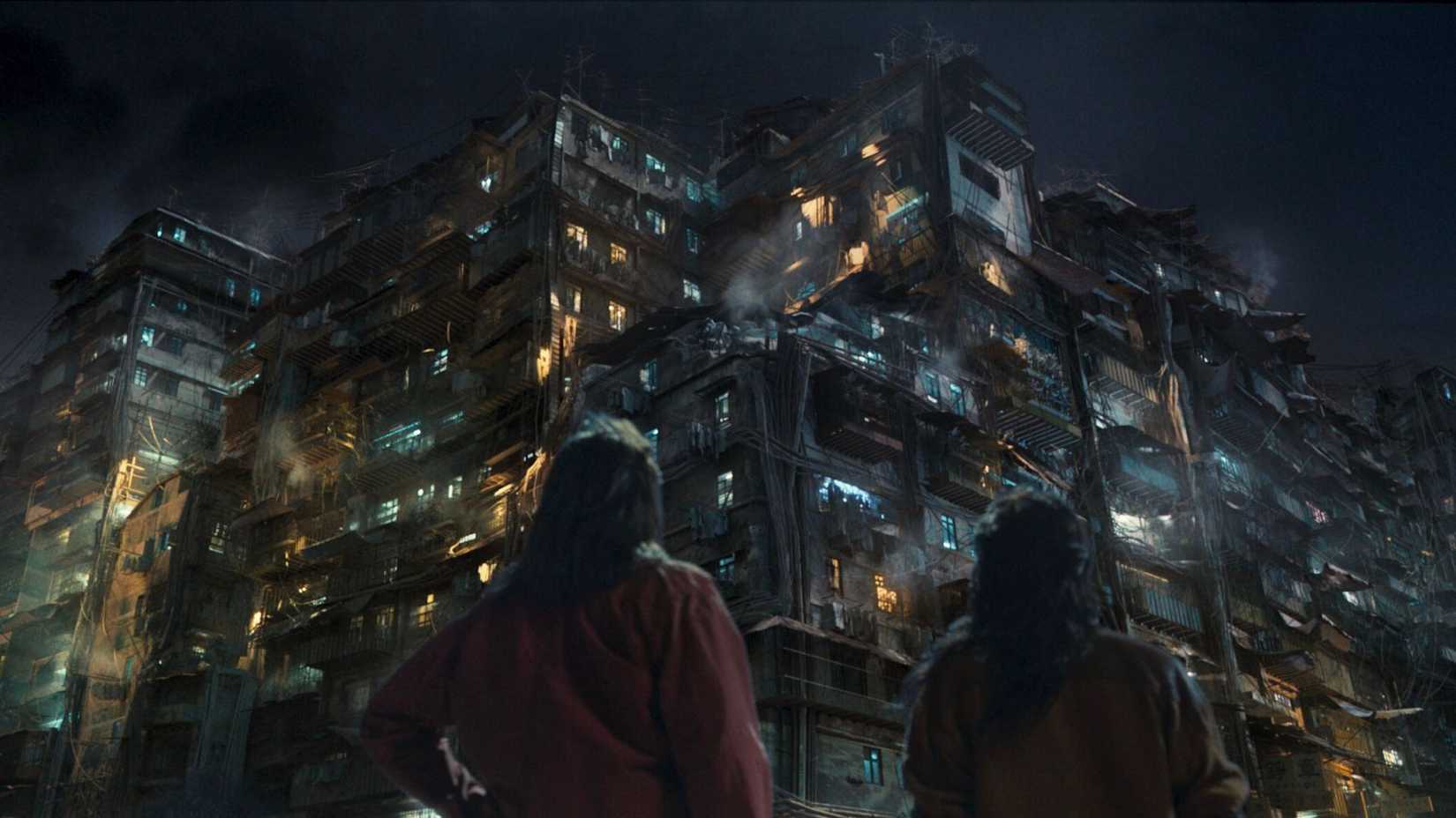 two people look up at a massive building in Twilight of the Warriors: Walled In