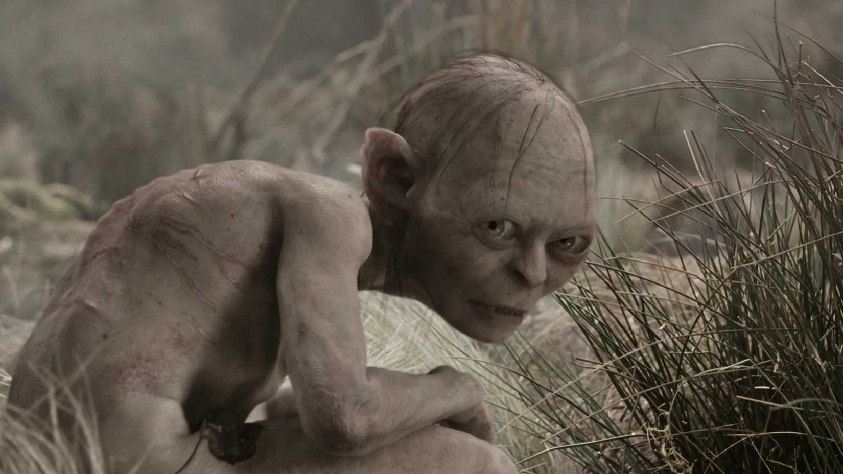 Gollum kneels in the weeds in The Lord of the Rings The Two Towers