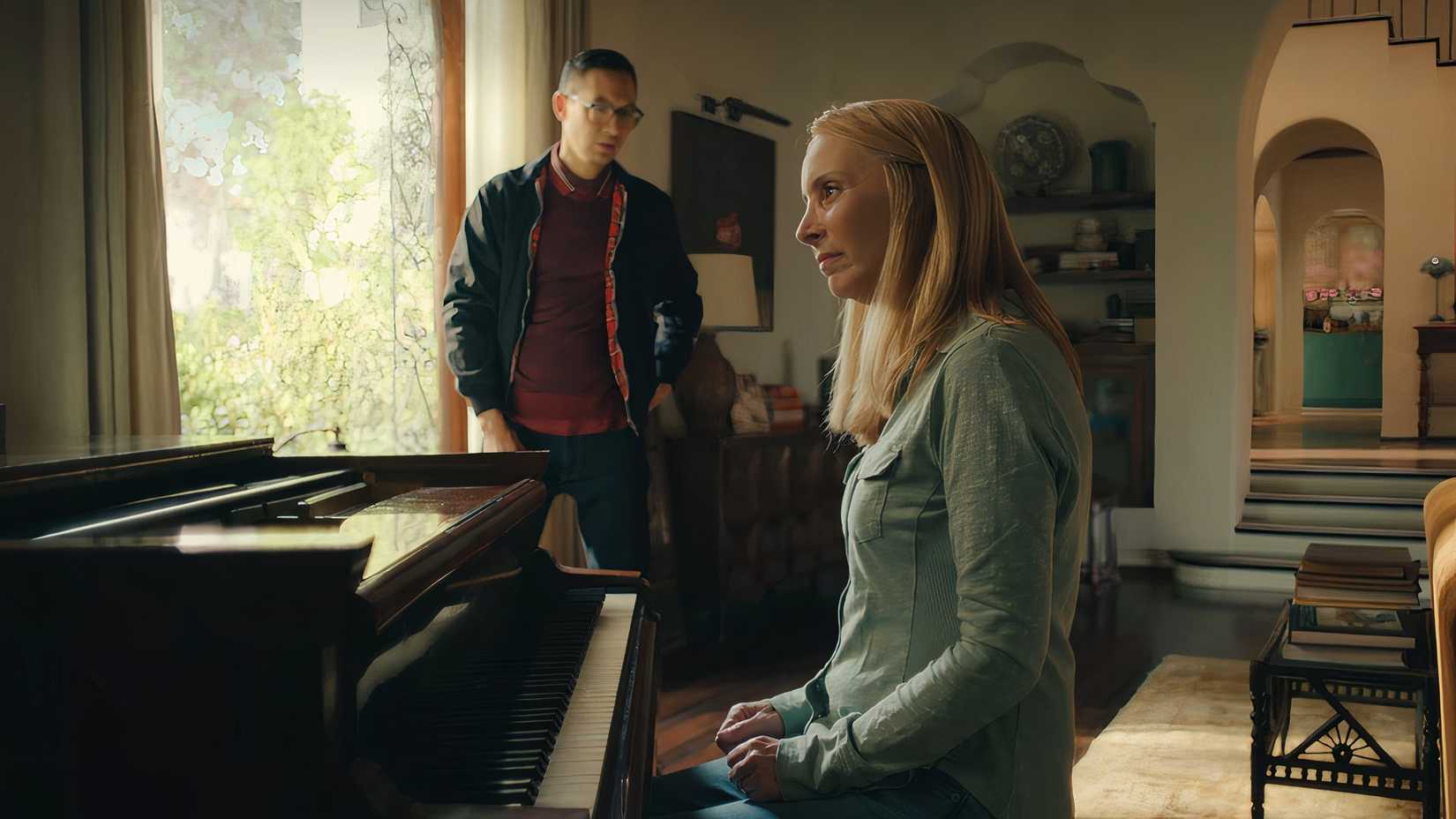 Lydia sits at the piano, unable to play.
