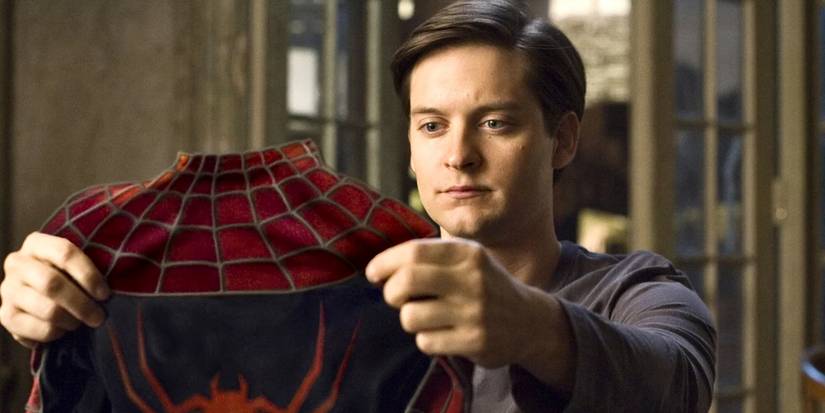 Tobey Maguire as Peter Parker holding suit in Spider-Man