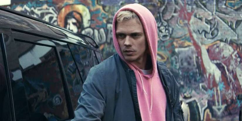 Bill Skarsgård as Eddie in Locked wearing a pink hoodie.