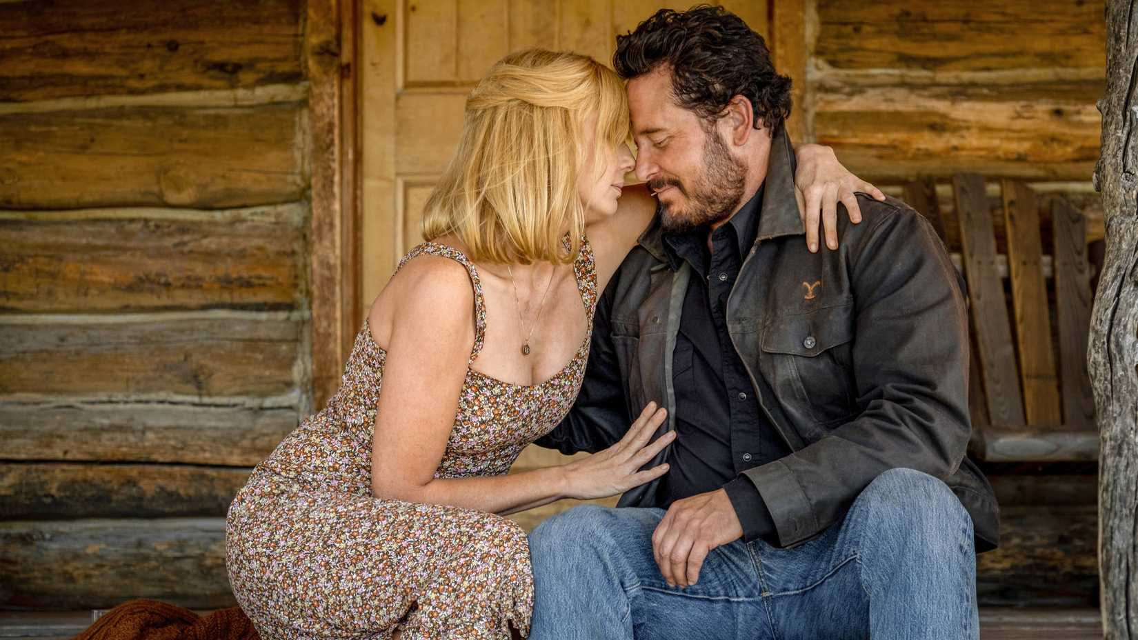 Beth and Rip hug on a porch in Yellowstone