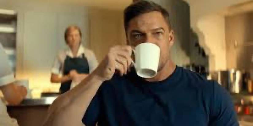 Alan Ritchson Drinking From a Cup as Reacher