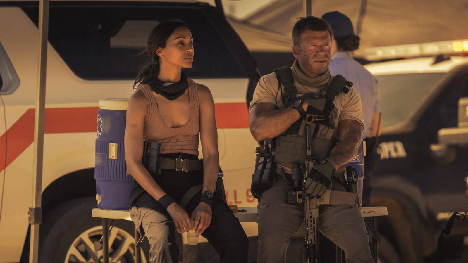 Joe and Cody sit by a cooler in Lioness