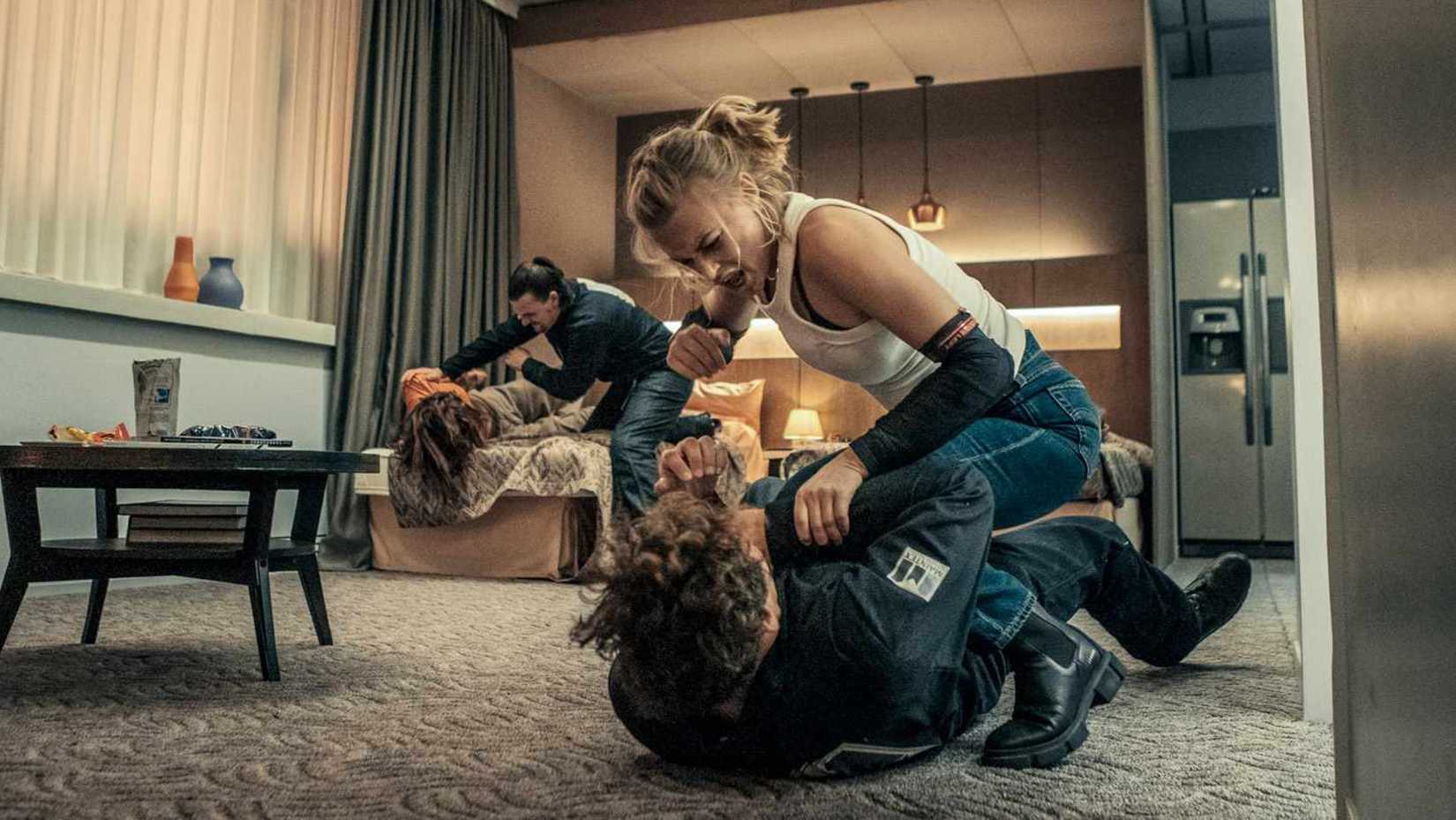 Sara fights a man on the ground in Exterritorial