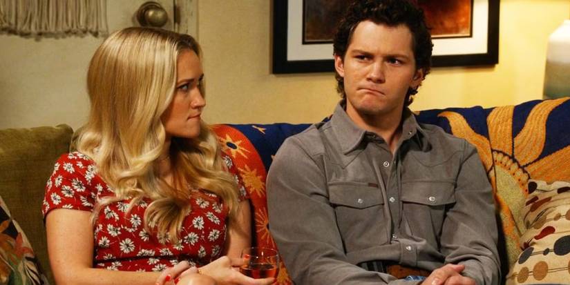 Emily Osment and Montana Jordan as Mandy and Georgie sit on a sofa in Georgie & Mandy's First Marriage 
