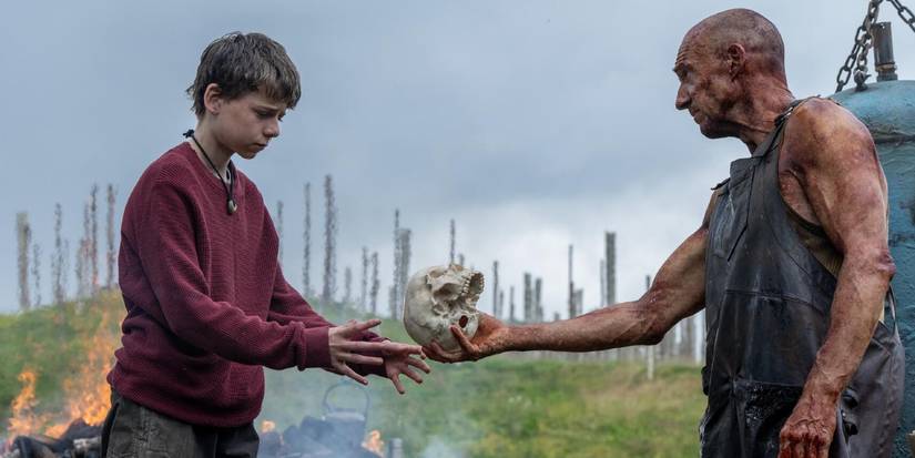 Alfie Williams and Ralph Fiennes in 28 Years Later holding a skull