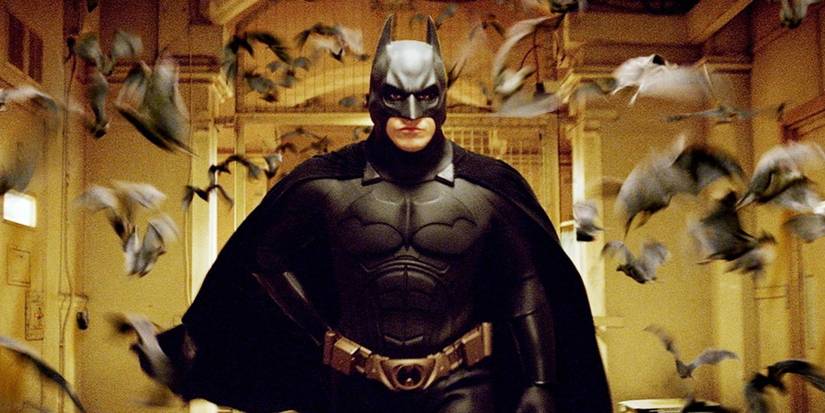 Still from Batman Begins with Christian Bale in the Batman suit with bats flying around him