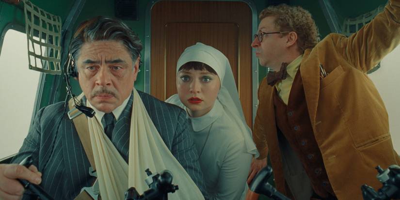 Benicio del Toro, Michael Cera, dan Mia Threapleton dalam The Phoenician Scheme