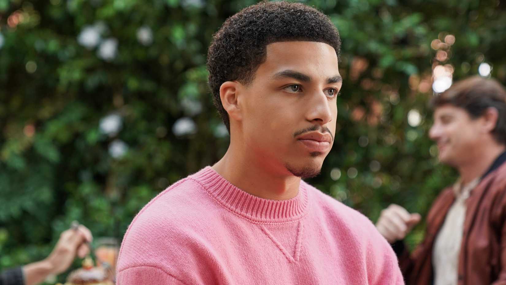 Junior wears a pink sweater in Grown-ish