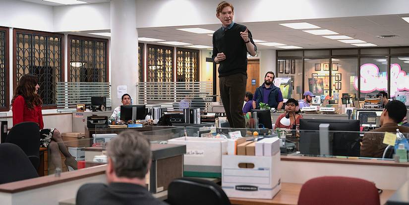Domhnall Gleeson's Ned Sampson standing on a desk in The Paper