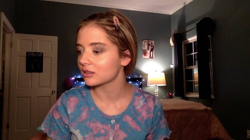 Seorang gadis di webcam dalam thumbnail trailer YouTube Strange Harvest.