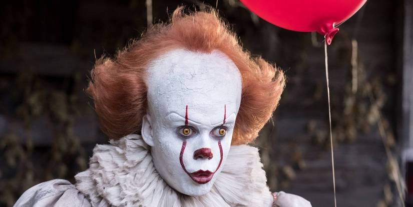 Bill Skarsgard as Pennywise holding a red balloon in It (2017)